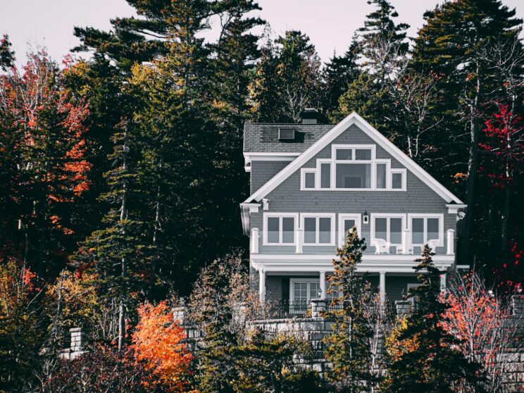 Elegant family home set against a vibrant autumn forest backdrop.